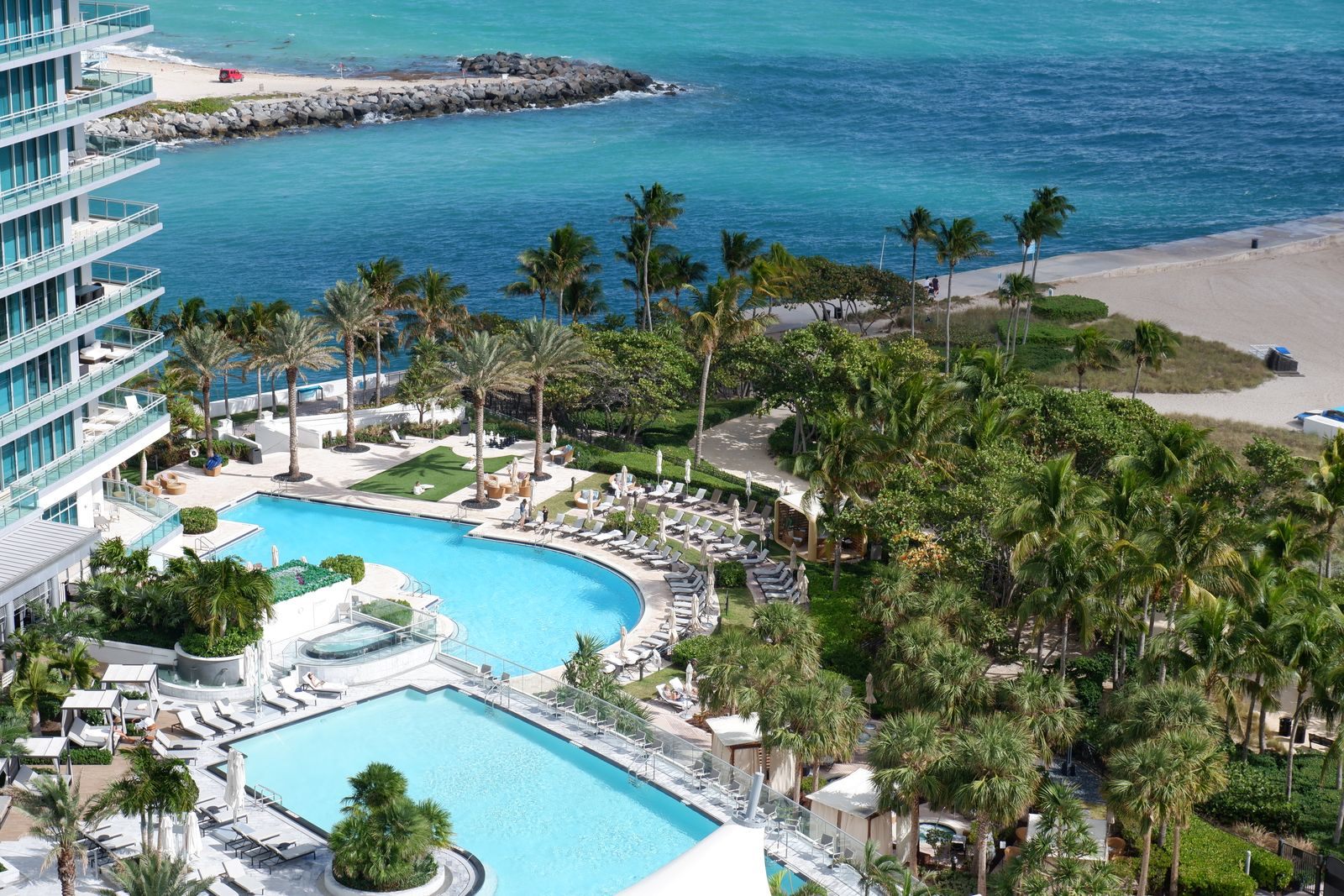 Resort pools and palm trees beside the beach in Miami